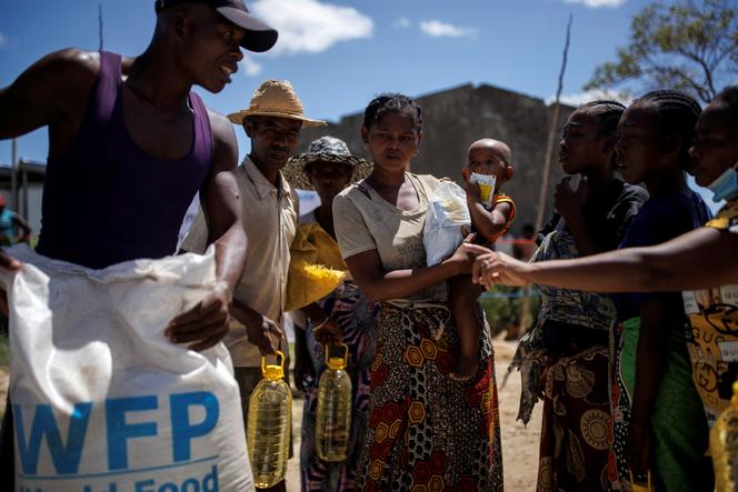A woman holds her child while waiting to receive products in a food distribution publication directed by the World Food Program in the Antanimora commune, Androy Region, Madagascar, on February 12, 2022.