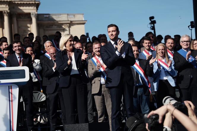 Marine Le Pen et Jordan Bardella saluent les participants au rassemblement en soutien au RN, sur la place Vauban, à Paris, le 6 avril 2025.