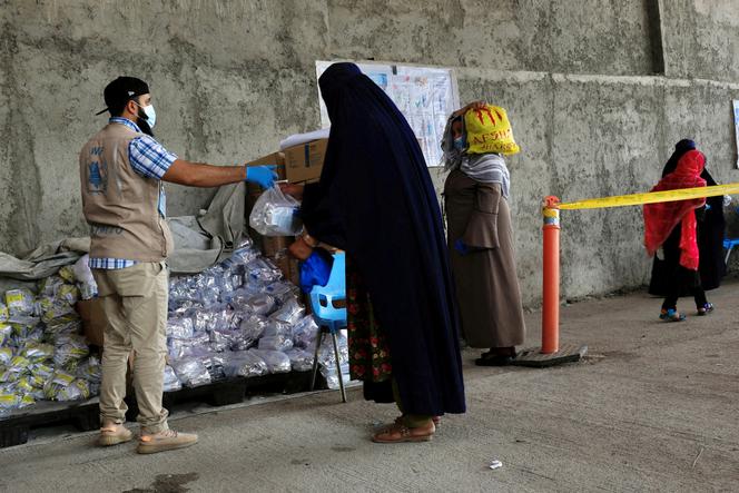 Une femme afghane reçoit des denrées alimentaires dans un centre de distribution du Programme alimentaire mondial à Kaboul (Afghanistan), le 21 août 2024.