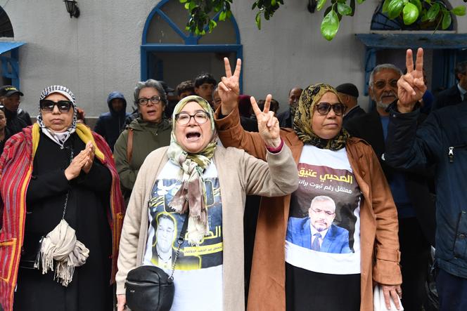 Les familles et les proches des figures de l’opposition politique détenues dans l’affaire dite de « complot contre la sûreté de l’État » brandissent des photos des détenus lors d’une manifestation devant le tribunal de Tunis, le 21 avril 2025.
