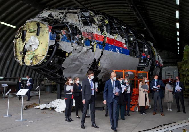 Des magistrats et des avocats examinent les restes du vol MH17 de la Malaysia Airlines, sur la base aérienne de Gilze-Rijen, aux Pays-Bas, le 26 mai 2021. 