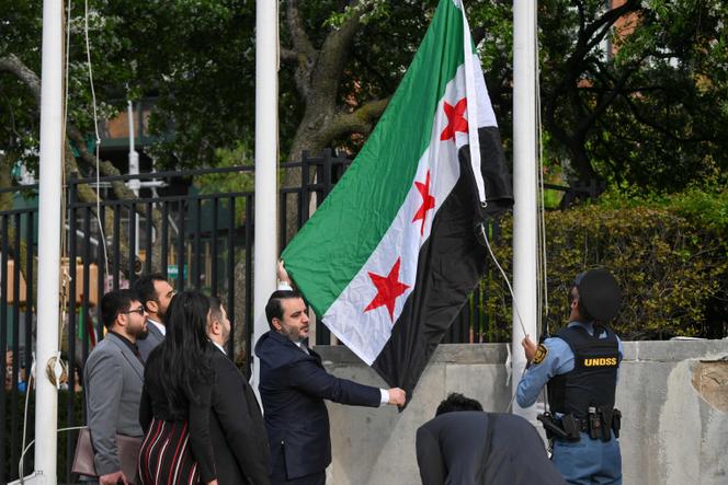 Le ministre syrien des affaires étrangères, Assaad Al-Chibani, brandit le nouveau drapeau syrien lors d’une cérémonie au siège des Nations unies, à New York, le 25 avril 2025.