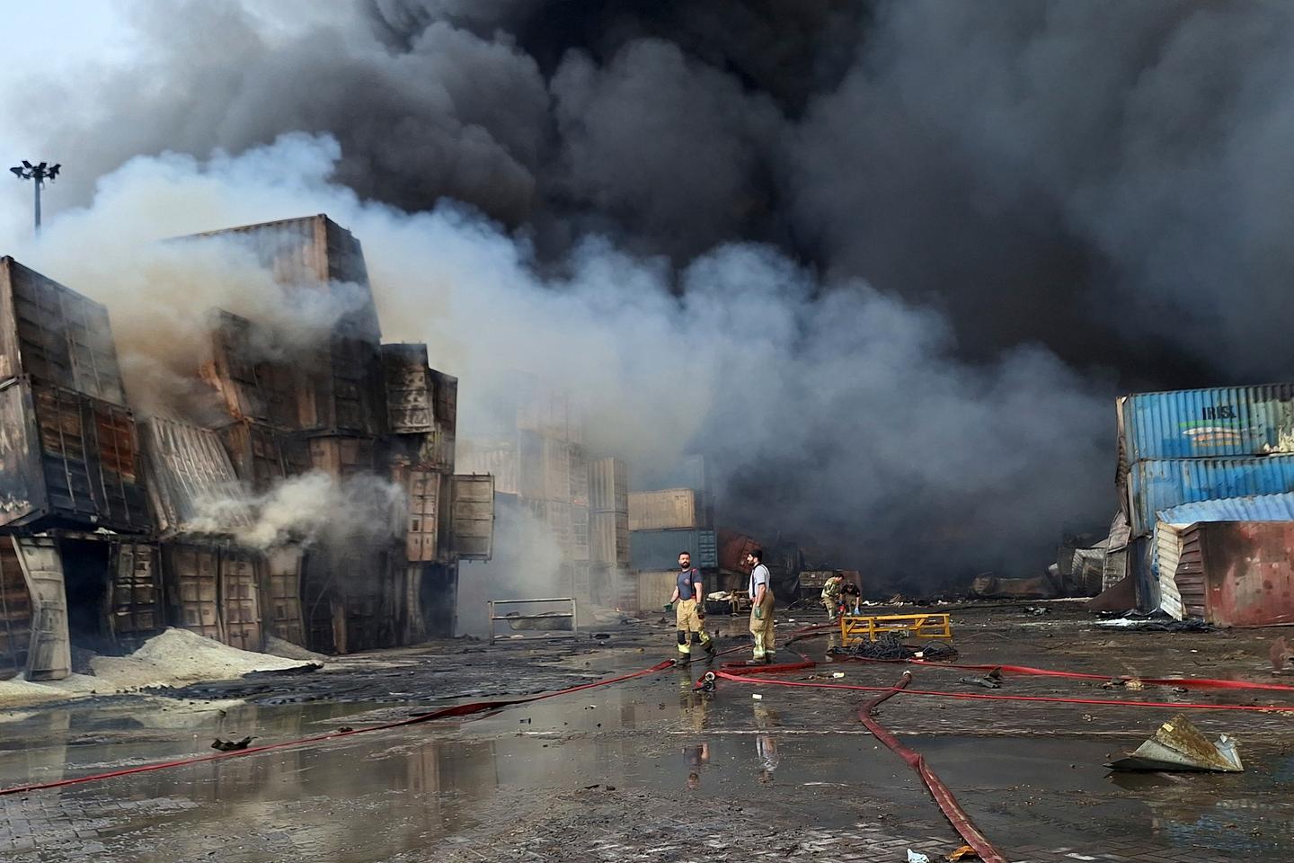 Firefighters fight to put out blaze after Iran port explosion leaves at least nine dead