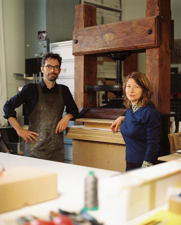 Paul Chamard e Laurel Parker em frente a uma imprensa de percussão do século XIX, em sua oficina em Romainville, em 8 de abril de 2025.