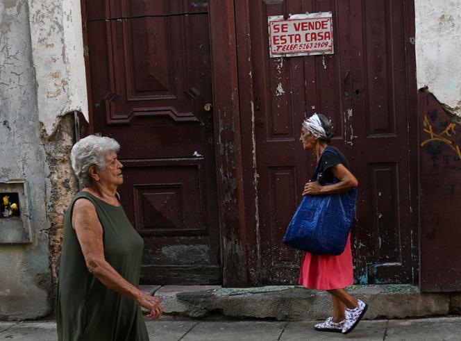 Des femmes passent devant une maison à vendre à La Havane, la capitale de Cuba, le 1er octobre 2024.