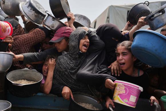 Des enfants palestiniens reçoivent des dons de nourriture dans un centre de distribution à Khan Younès, dans la bande de Gaza, le 21 avril 2025.