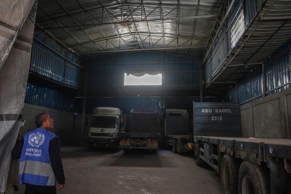 Un membre du personnel montre un entrepôt de l’UNRWA vide, dans la ville de Gaza, le 28 avril 2025.
