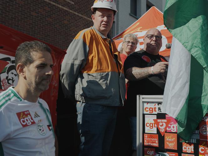Gaëtan Lecocq, secrétaire général CGT d'ArcelorMittal Dunkerque (au centre), Christelle Veignie, secrétaire générale de l'union locale CGT Dunkerque, et Jean Paul Delescaut, secrétaire général de l'UD-CGT du Nord Dunkerque, lors d’un rassemblement en soutien aux salariés d’ArcelorMittal, à Dunkerque, le 1ᵉʳ mai 2025.