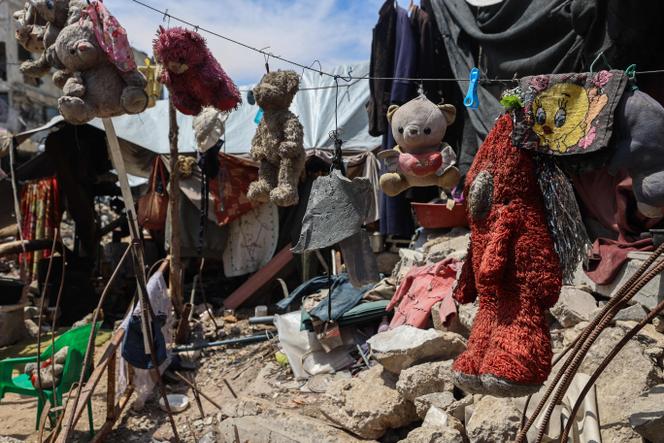 Des jouets ayant appartenu aux enfants du Palestinien Wissam Wishah, – Saïd, Salma et Eline –, tués lors de frappes israéliennes, sont suspendus à une corde à linge sur les décombres de leur maison, dans le camp de réfugiés d’Al-Bureij, dans le centre de la bande de Gaza, le 1ᵉʳ mai 2025.