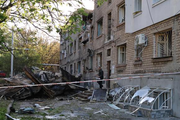 Un habitant sort ses affaires d’un immeuble endommagé par une attaque de drone, qui a fait plus de 30 blessés, à Zaporijia, le 2 mai 2025.