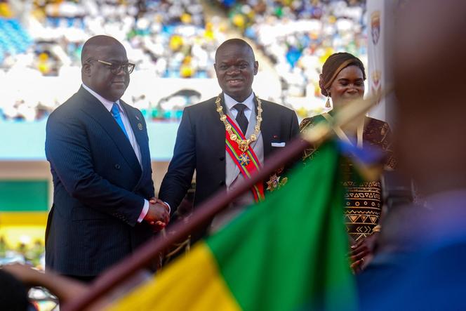 President of Gabon Brice Oligui Nguema Brice Oligui Nguema (C) shakes hands with President of the Democratic Republic of the Congo Felix Tshisekedi (L) during his swearing-in ceremony at a stadium in Libreville on May 3, 2025.