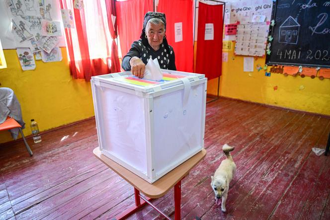 Une électrice dépose son bulletin dans une urne à Popesti, le 4 mai 2025.