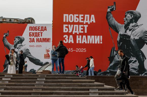 Des personnes près des décorations installées avant les célébrations du 80e anniversaire de la victoire sur l’Allemagne nazie, pendant la seconde guerre mondiale, dans le centre de Moscou, en Russie, le 5 mai 2025.