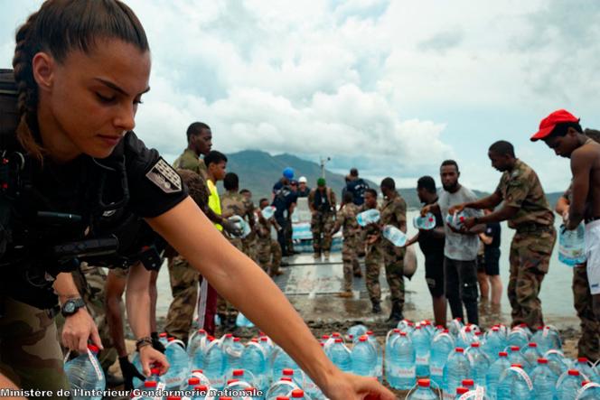 Members of the French Navy, the Adapted Military Service Regiment (RSMA) and gendarmes unloading bottles of water on a beach in Hanyoundrou, following the passage of the Tropical Cyclone Chido, in Mayotte, on December 28, 2024.