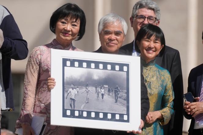 Le photographe Nick Ut, lauréat des prix Pulitzer et World Press Photo pour sa photographie dite de « la fille au napalm », tient la célèbre photographie dans ses mains, alors qu’il attend de rencontrer le pape François, au Vatican, le 11 mai 2022.