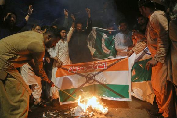 Des manifestants brûlent un drapeau indien, à Hyderabad, au Pakistan, le 7 mai 2025.