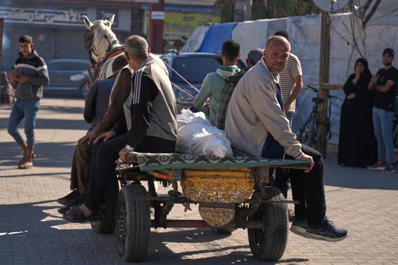 Des Palestiniens transportent le corps d’un homme tué par une frappe israélienne, à Deir Al-Balah, dans le centre de la bande de Gaza, le 7 mai 2025.