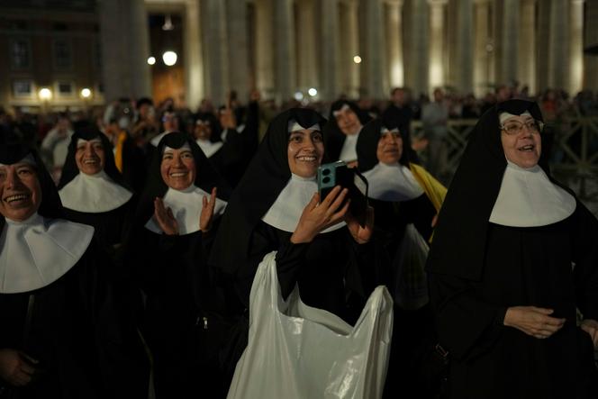 Un groupe de religieuses apercevant la fumée noire sortant de la cheminée de la chapelle Sixtine, place Saint-Pierre, à Rome, le mercredi 7 mai 2025.