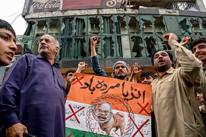 Des Pakistanais scandent des slogans anti-indiens devant devant un immeuble détruit après le tir présumé d’un drone, à Rawalpindi, le 8 mai 2025.