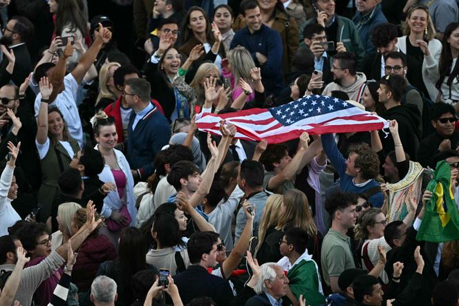 Des personnes brandissent et secouent le drapeau des Etats-Unis, après l’élection du pape Léon XIV, place Saint-Pierre au Vatican, le 8 mai 2025.