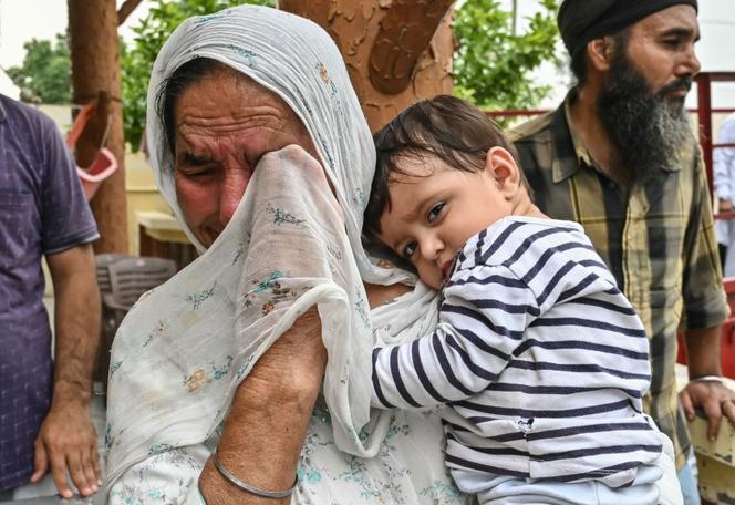 Une femme évacuée porte un enfant, à la suite d’une montée des tensions frontalières, dans le village de Havelian (Pakistan), près du poste-frontière indo-pakistanais, à environ 45 km d’Amritsa (Inde), le 9 mai 2025.