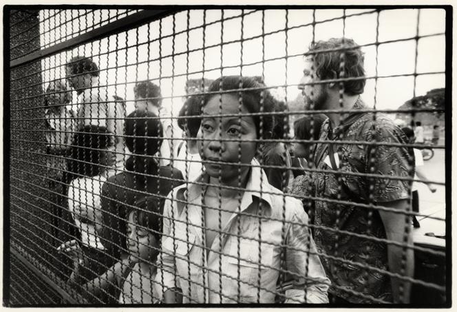 Réfugiés français et étrangers, derrière le grillage protégeant l’ambassade de France, à Phnom Penh, le 17 avril 1975.