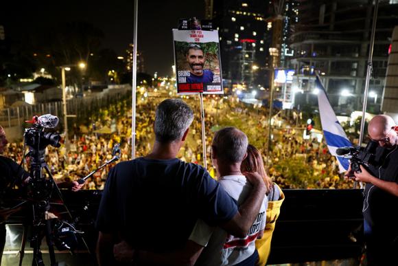 Los manifestantes sostienen una pancarta exigiendo la liberación de Tamir Adar, quien ha estado secuestrado en la Franja de Gaza desde el ataque de Hamas el 7 de octubre de 2023, en Tel Aviv el sábado por la noche.