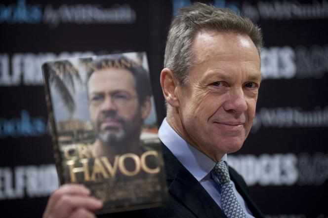 L’ancien officier de l’armée britannique Simon Mann pose pour les photographes avec son livre « Cry Havoc » lors d’une séance de dédicaces dans le centre de Londres, le 14 décembre 2011.