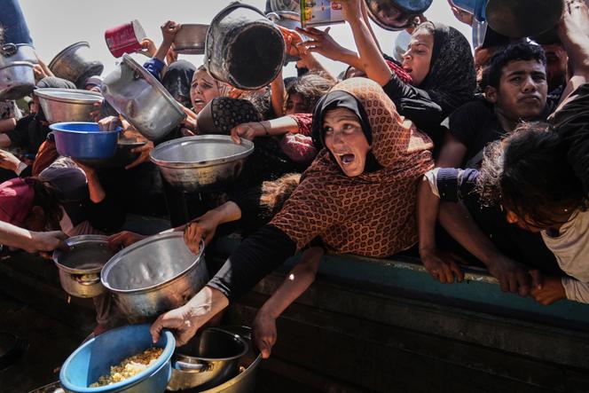 Des Palestiniens luttent pour obtenir de la nourriture donnée dans une cuisine communautaire à Khan Younès, dans le sud de la bande de Gaza, vendredi 9 mai 2025.