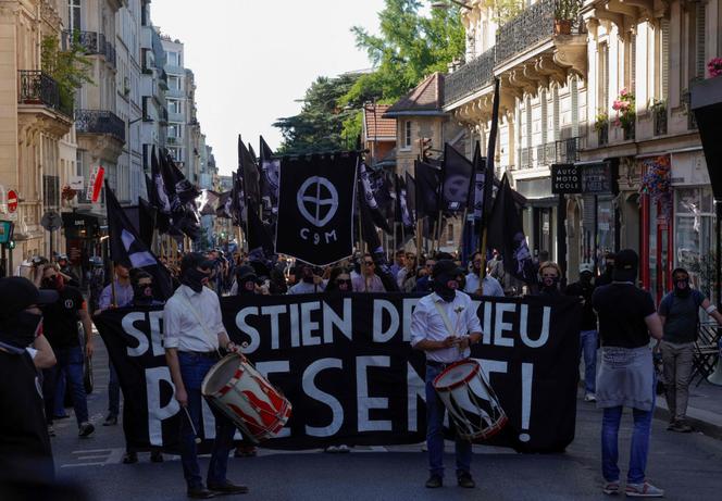 Les membres du groupuscule néonazi du Comité du 9 mai marchent derrière une banderole, alors qu’ils participent à une manifestation pour commémorer la mort du militant d’extrême droite Sébastien Deyzieu, à Port-Royal à Paris, le 10 mai 2025.