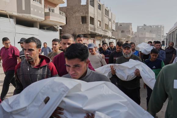 Des Palestiniens portent les corps des personnes tuées lors d’une frappe aérienne israélienne nocturne, à Khan Younis, dans la bande de Gaza, le 11 mai 2025.