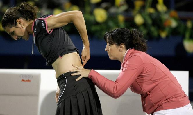 La Française Virginie Razzano (à gauche) reçoit les soins d’un kinésithérapeute pour des douleurs lombaires lors de la finale des championnats de tennis WTA de Dubaï contre l’Américaine Venus Williams, dans l’émirat du Golfe, le 21 février 2009.