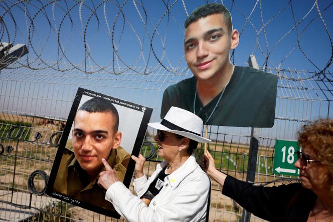 Varda Ben Baruch, grand-mère de l’otage Edan Alexander, avec des portraits de son petit-fils, lors d’une manifestation de soutien aux captifs, au kibboutz Nir Oz (Israël), à la frontière avec la bande de Gaza, le 20 avril 2025.