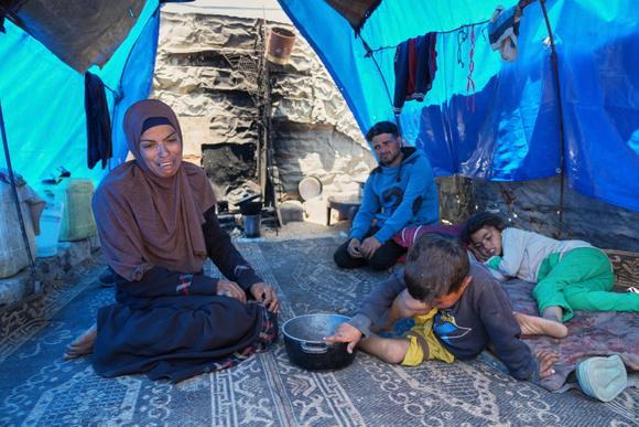 Une famille revenue les mains vides d’une tentative de réception de nourriture, près d’une cuisine communautaire, à Khan Younès, dans le sud de la bande de Gaza, le 9 mai 2025.