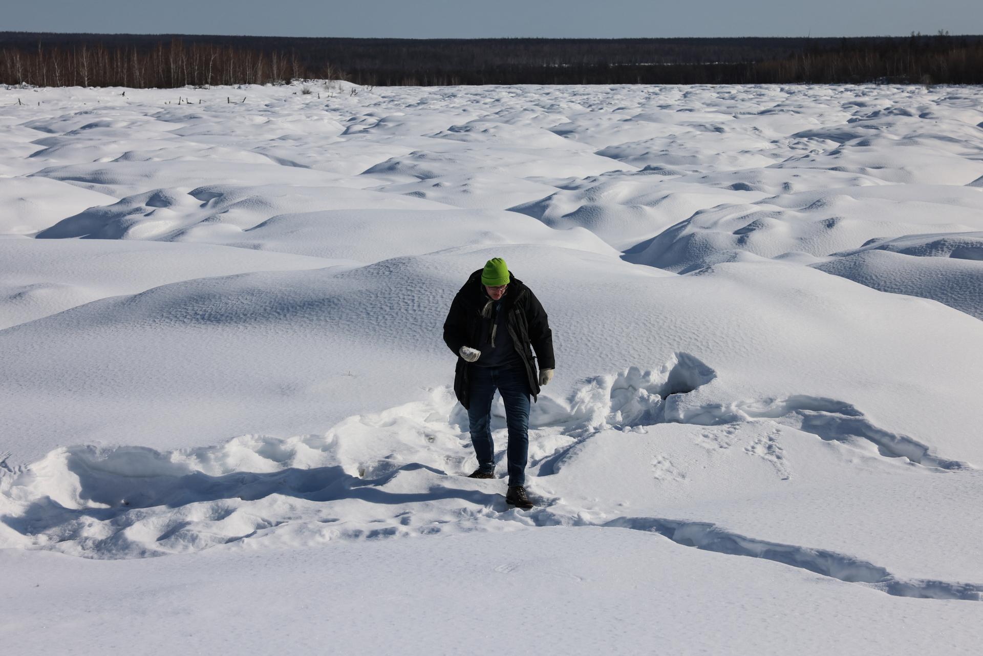 Le directeur du laboratoire du climat de l’Université fédérale du Nord-Est, Nikita Tananaev, dans le paysage déformé par les « bylars » à Tchouraptcha (Sibérie orientale), le 29 mars 2025.