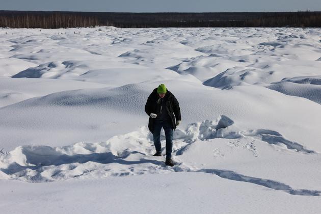 The director of the climate laboratory at the North-Eastern Federal University, Nikita Tananaev, in the landscape deformed by the 'bylars' in Churapcha, Eastern Siberia, March 29, 2025.