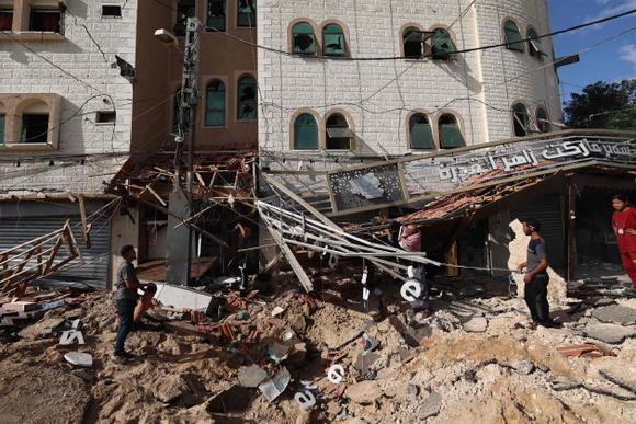 Des personnes inspectent les décombres d’un bâtiment à la suite d’un bombardement israélien sur Khan Younès, dans le sud de la bande de Gaza, mercredi 14 mai 2025.