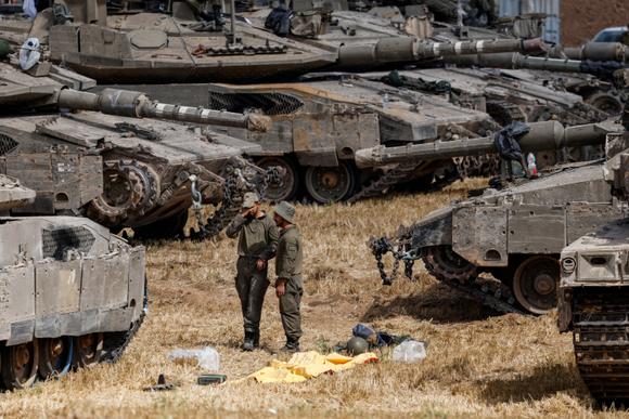 Des soldats israéliens à côté de véhicules militaires, près de la frontière entre Israël et Gaza, en Israël, mercredi 14 mai 2025.