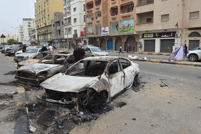Des voitures brûlées après des combats entre milices rivales, à Tripoli, le 14 mai 2025.