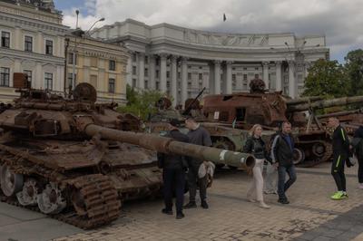 Des Ukrainiens devant des véhicules militaires russes détruits, exposés sur la place Saint-Michel, à Kiev, le 14 mai 2025.