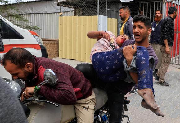 Un homme transporte un blessé à l’hôpital Nasser après une frappe israélienne, à Khan Younès, dans le sud de la bande de Gaza, jeudi 15 mai 2025.