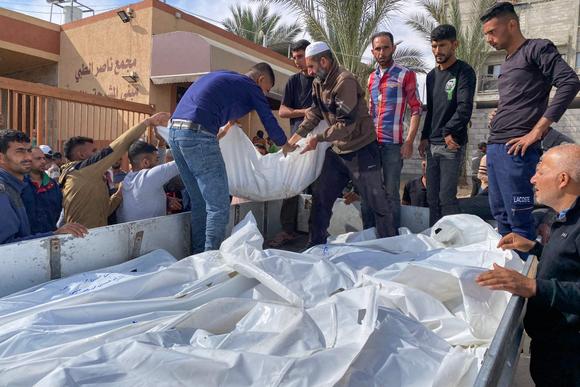 Des personnes placent les corps des victimes de bombardements israéliens à l’arrière d’un camion avant leur enterrement, à l’hôpital Nasser de Khan Younès, jeudi 15 mai 2025.