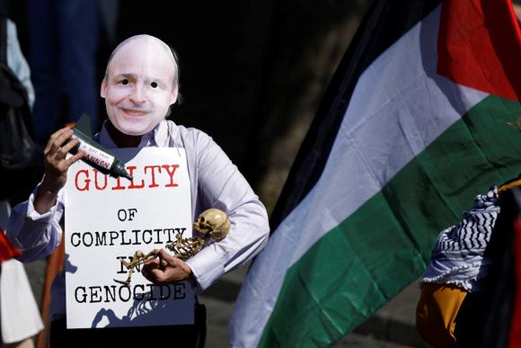 Un homme portant un masque représentant le premier ministre irlandais, Micheal Martin, lors d’une manifestation de soutien aux Palestiniens de Gaza à Dublin, samedi 17 mai 2025.