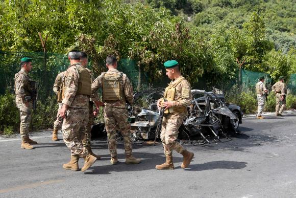 Des soldats de l’armée libanaise devant une voiture ciblée par une attaque de drone israélien, à Abou al-Aswad, dans le sud du Liban, le 17 mai 2025.