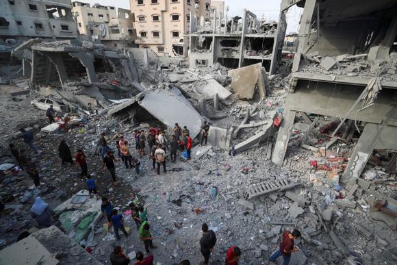 Des personnes fouillent dans les décombres après une frappe israélienne à Jabalia, dans le nord de la bande de Gaza, dimanche 18 mai 2025.