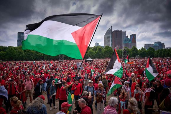 Des milliers de personnes, vêtues de rouge, se rassemblent à La Haye, dimanche 18 mai 2025.