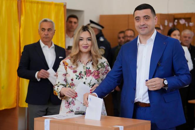 Le candidat à la présidence, George Simion, vote avec son épouse, lors du second tour de l’élection présidentielle à Mogosoaia, en Roumanie, le 18 mai 2025.