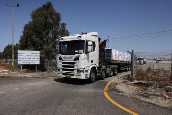 Des camions transportant de l’aide humanitaire se dirigent vers Gaza, du côté israélien du point de passage de Kerem Shalom, le 19 mai 2025.