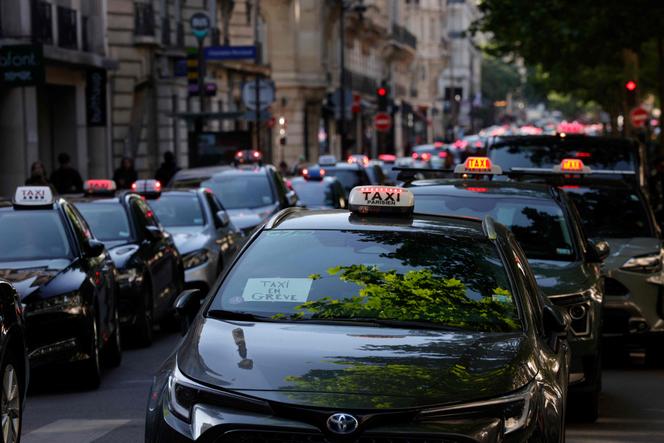 Des chauffeurs de taxi se rassemblent dans une rue de Paris, le 19 mai 2025, lors d’une manifestation nationale contre les changements proposés dans la manière dont l’Etat finance les services de transport médical.