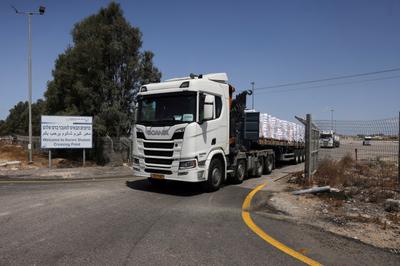 Des camions transportant de l’aide humanitaire se dirigent vers Gaza, du côté israélien du point de passage de Kerem Shalom, le 19 mai 2025.